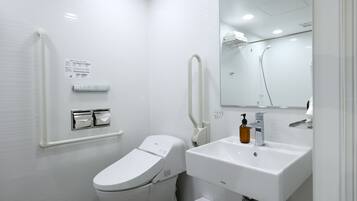 Un baño moderno con inodoro, lavabo y espejo.