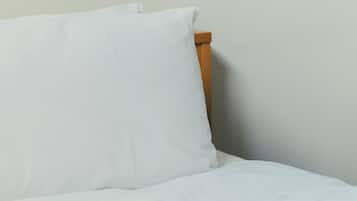 A bed with white bedding and a wooden headboard.
