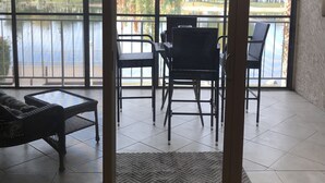 Ein Zimmer mit Seeblick, einem Deckenventilator und einer Sitzecke mit Stühlen und einem Tisch.