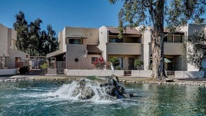 Ein Wohngebiet mit Schwimmbad, Wasserfall und Apartmentgebäuden im Hintergrund.