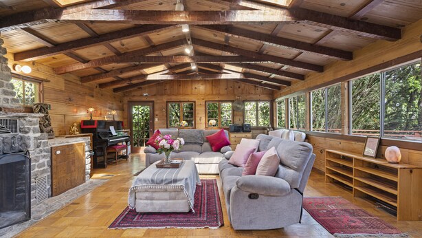 A spacious living room with a high wooden ceiling, a fireplace, a piano, and large windows offering a view of the outdoors. - Spacious Serene Sanctuary-Minutes to SF and Muir Woods (Mill Valley)