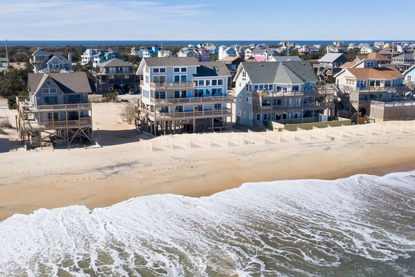 A beachfront property with multiple-story buildings, a sandy beach, and a view of the ocean. - Sunrises, Sunsets☀️Hot Tub, Shared Pool, Beach Chairs, Oceanfront, SUMMER SALE (Avon)
