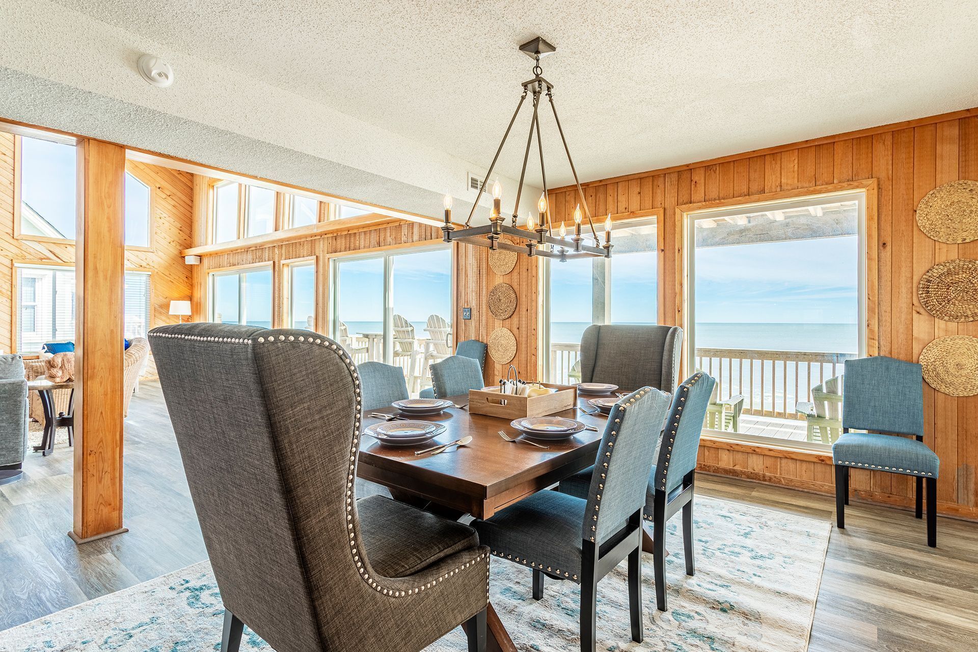 A dining area with a wooden table, chairs, and a chandelier.