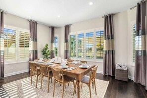 A dining room with a wooden table set for six, surrounded by chairs. - Ritz Waters at Ocotillo, Heated Pool, 5br/3.5 bath (Chandler)