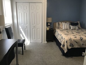 A bedroom with a bed, a desk, a chair, a nightstand, and a wardrobe. - Single Level Home - Steps to Downtown Gloucester & A/C throughout  (Gloucester)