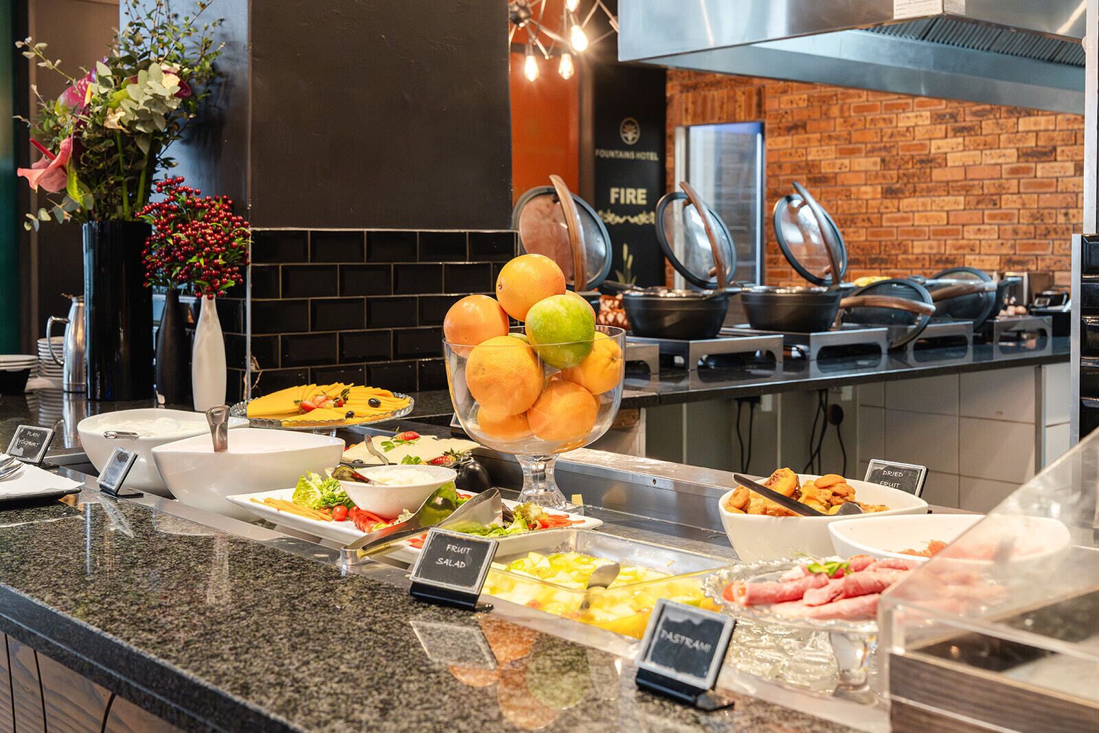 A buffet with various food options including fruits, salads, and meats.