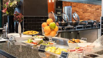A buffet with various food options including fruits, salads, and meats.