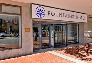 L'ingresso dell'Hotel Fountains, con una porta in vetro e un cartello sopra.