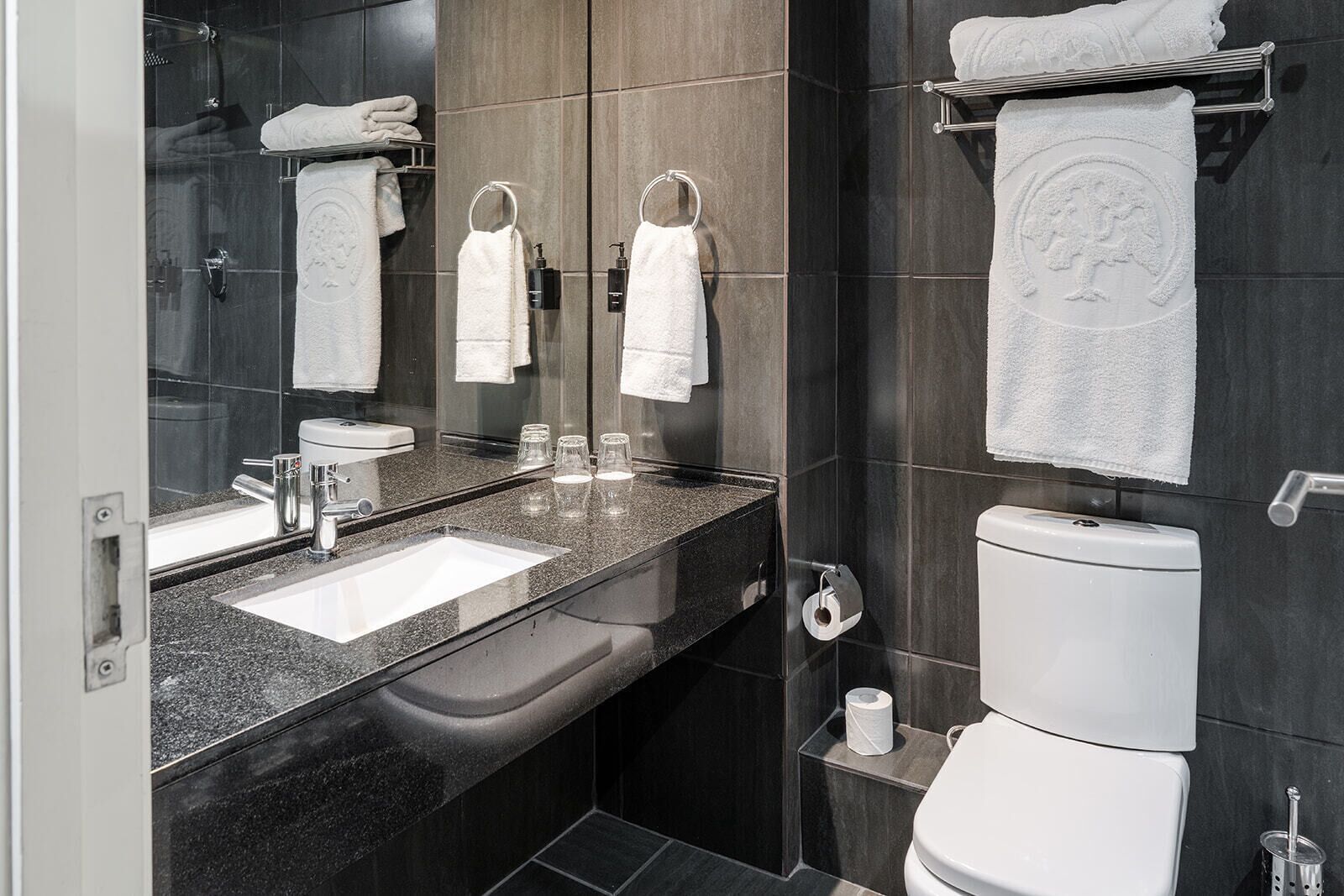 Une salle de bain moderne avec un double vasque, des toilettes et une douche à l’italienne.