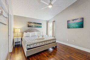 Cozy retreat with a large bed, nightstand, and ceiling fan.