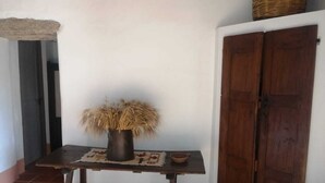 Une pièce rustique avec une table en bois, un panier tressé et une porte.