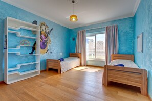 A room with two wooden beds, a white shelving unit, and a mural on the wall. - Seafront Apartment in Sliema With Pool, Upmarket Complex (Sliema)