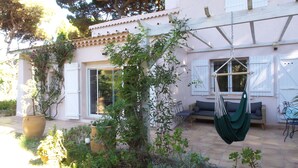 Una casa con un patio, una silla colgante y un sofá.