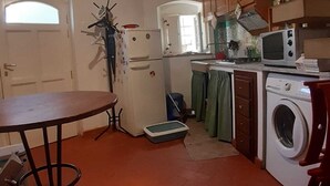 Una cocina compacta con una mesa de comedor, lavadora, microondas y refrigerador.