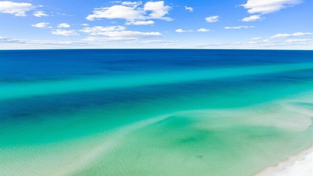 Una playa con agua turquesa cristalina y arena blanca.