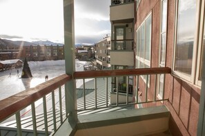En balkong med utsikt över ett snötäckt landskap och byggnader.