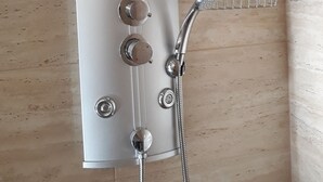 Een douche met een handdouche en een wanddouche.