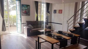 Un salon moderne avec un canapé, une table à manger et un escalier.