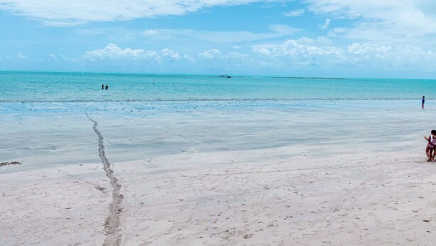 A beach with clear turquoise water and a sandy shore. - Casa de Praia Condomínio Fechado em Ipioca (Maceió)
