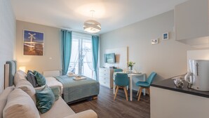 Una habitación de hotel moderna con cama, sofá, escritorio y kitchenette.
