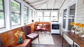 A covered porch with wooden benches, a dining table, and potted plants. - Fun Downtown Location 2nd flr (Southington)