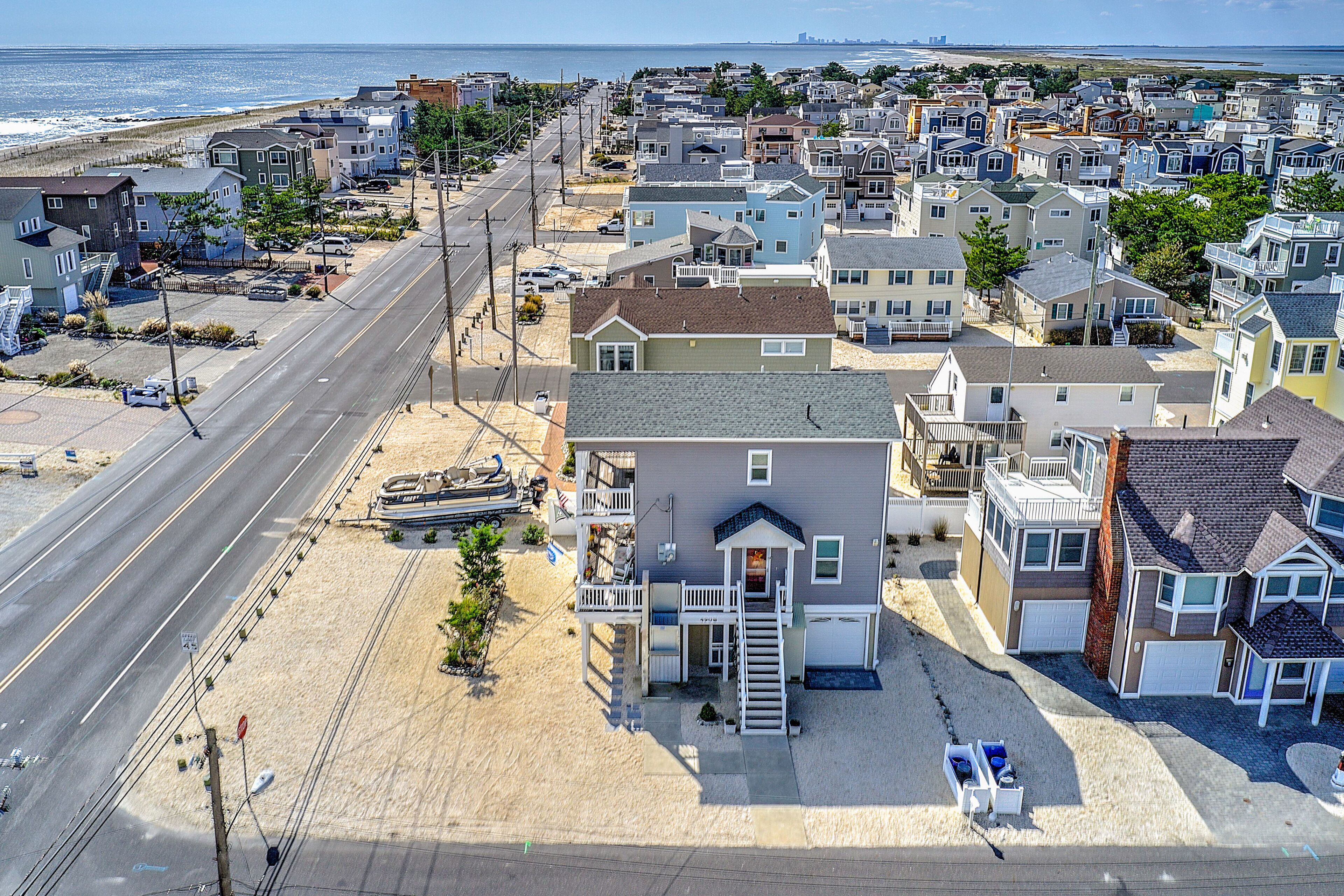 A coastal residential area with houses, a beach, and a road.