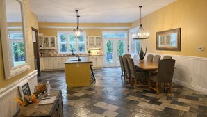 A spacious kitchen with a central island, a dining area with a wooden table and chairs, and large windows providing natural light. - Bruce “GOLF” Getaways (Lion's Head)