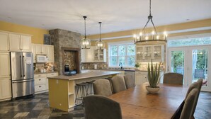 A spacious kitchen with a large island, stainless steel appliances, and a stone accent wall. - Bruce “GOLF” Getaways (Lion's Head)