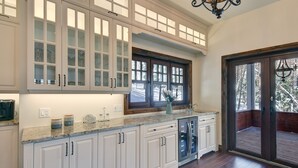 A kitchen with white cabinets, a granite countertop, and a large window.
