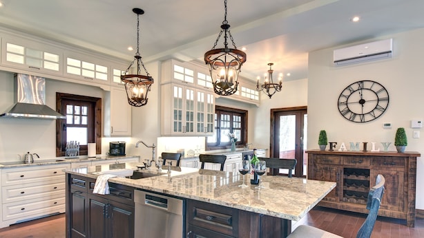 A spacious kitchen with a large island, dark cabinetry, and pendant lighting.
