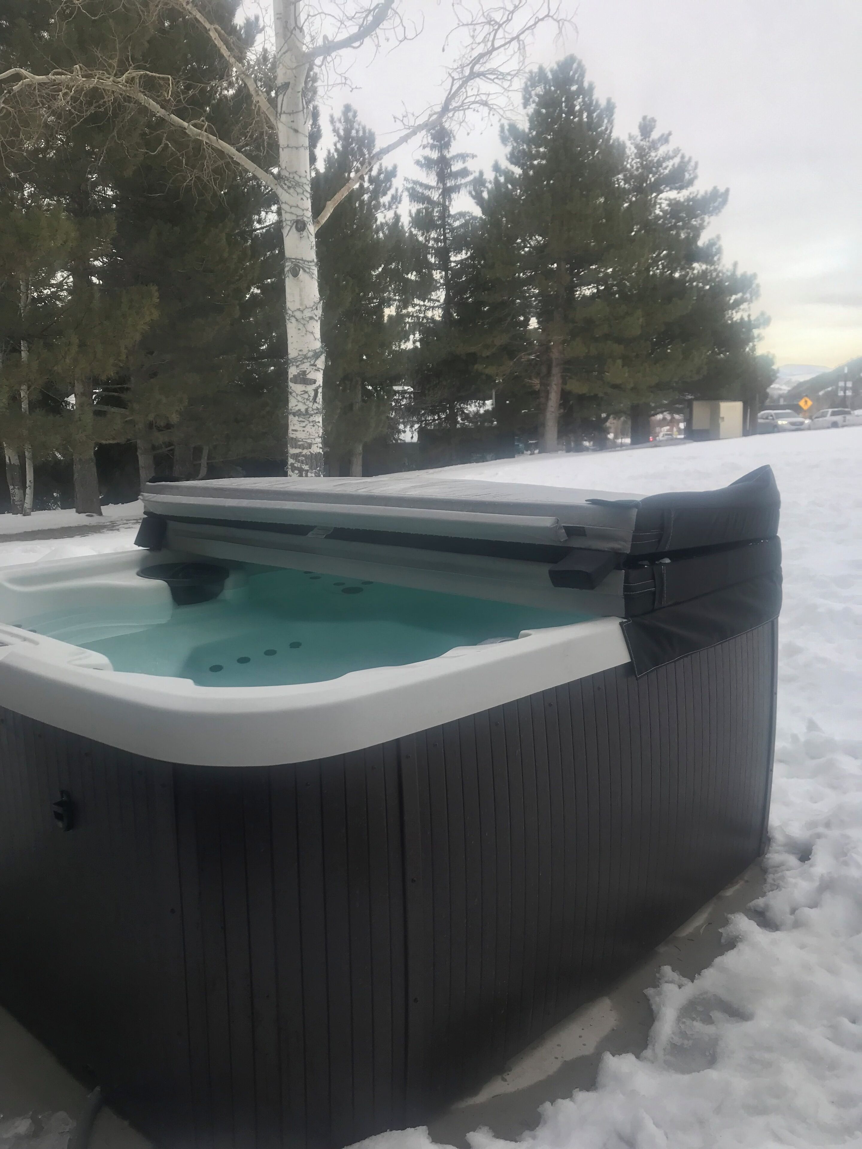 Un bain à remous installé à l’extérieur, dans un décor enneigé.