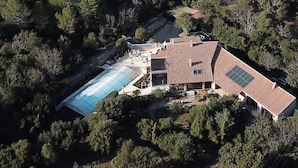 An aerial view of a house with a large swimming pool, a covered patio, and a garden area. - Totally private 8 adults plus 2 children luxe villa with heated swimming pool (Régusse)