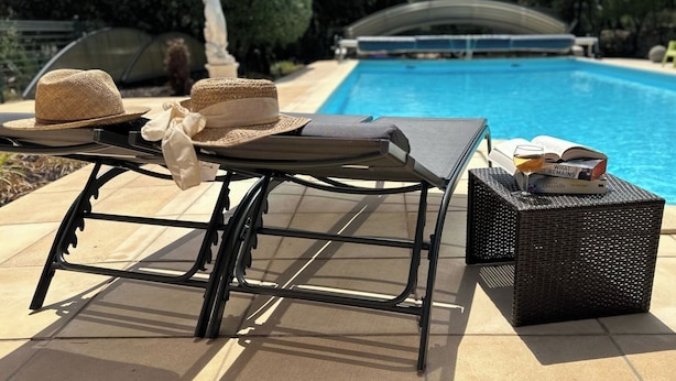 A poolside lounge area with a table, two sun loungers, a wicker basket, and a straw hat. - Totally private 8 adults plus 2 children luxe villa with heated swimming pool (Régusse)