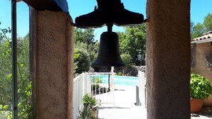 A bell tower with a view of a swimming pool and greenery in the background. - Totally private 8 adults plus 2 children luxe villa with heated swimming pool (Régusse)