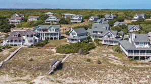 A coastal residential area with multiple houses featuring large porches and waterfront views. - "La Dolce Vita" BHI Club, Pet Friendly, Duplex, Steps to Beach (Bald Head Island)