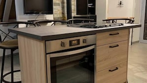 Una cocina moderna con horno empotrado, estufa y un reloj digital que marca las 20:28.