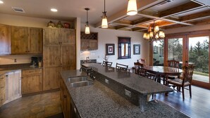 Una cocina con armarios de madera, encimeras de granito e iluminación colgante.