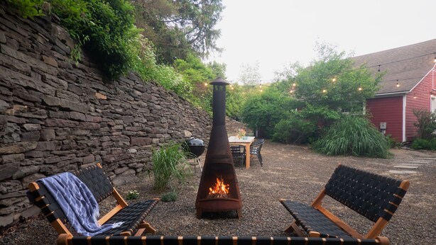 A stone wall, a fire pit, and two lounge chairs in a garden setting. - Renovated Catskills Farmhouse - hiking, swimming, quaint towns, 1st floor living (Denver)