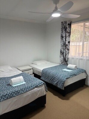 3 dormitorios y tabla de planchar con plancha