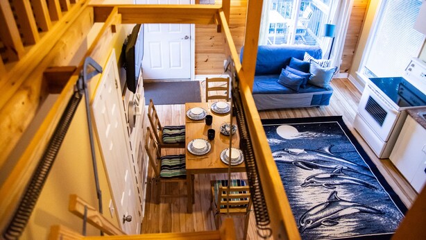 Un intérieur en bois comprenant un coin repas, une cuisine et un canapé offrant une vue agréable.