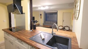 A modern kitchen with a wooden countertop, a sink, and a built-in stove.