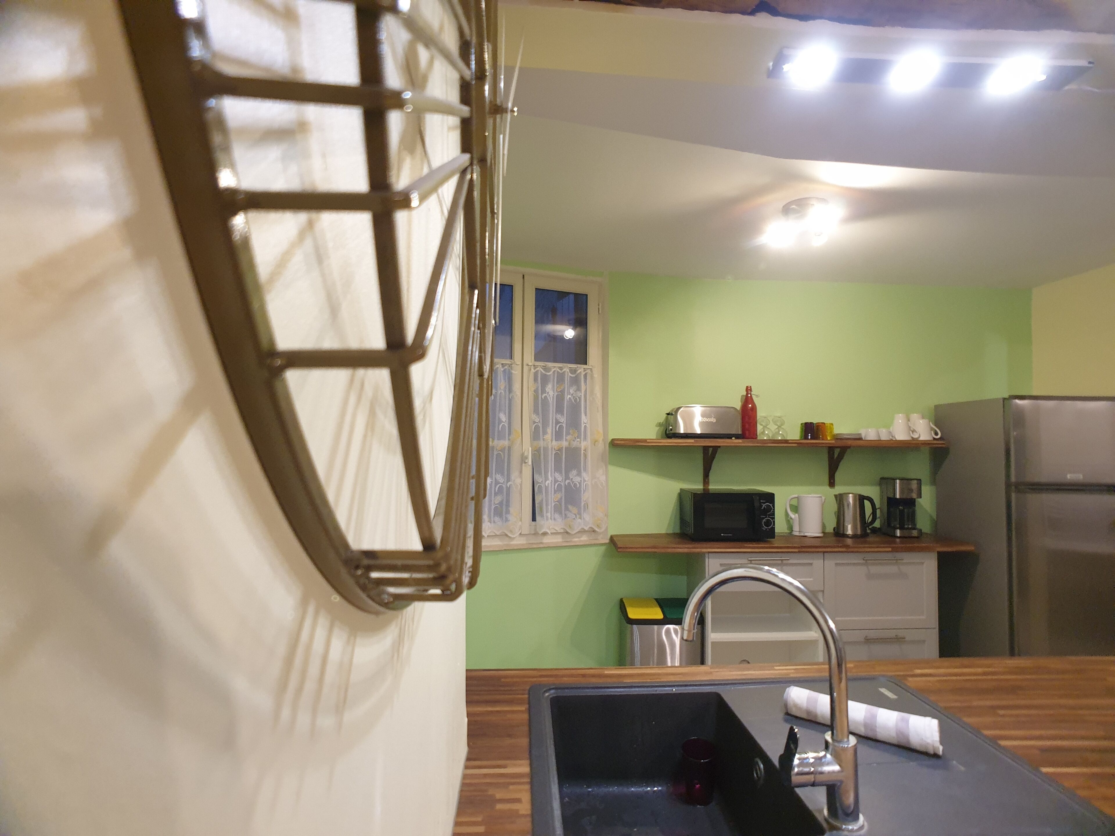 A kitchen with a sink, a microwave, a toaster, and a refrigerator.