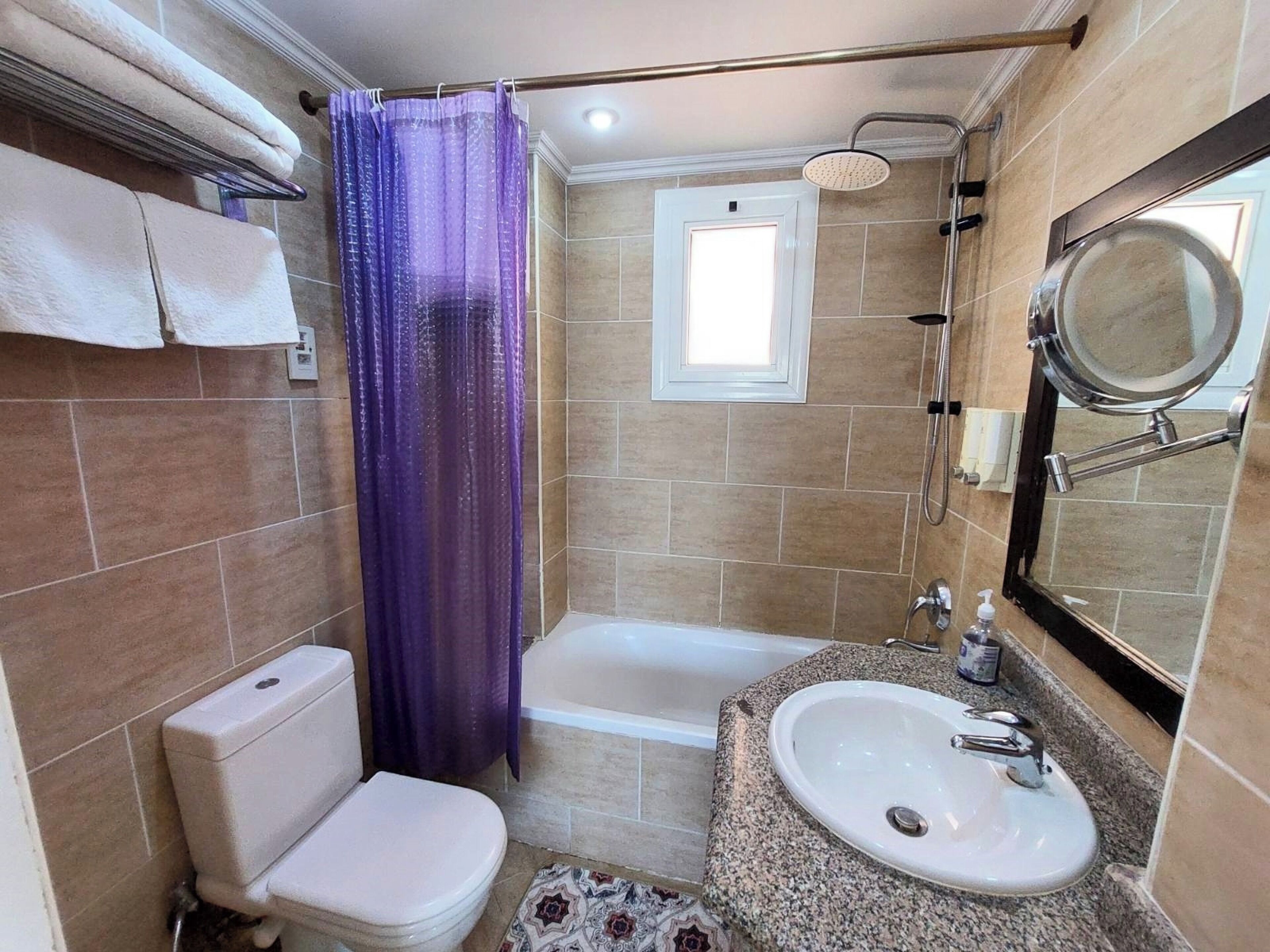 Une salle de bain comprenant des toilettes, une baignoire et un lavabo.