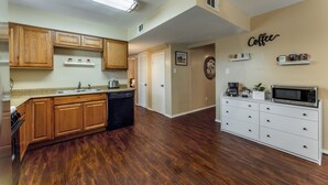 A kitchen with wooden cabinets, a dishwasher, a microwave, and a coffee station. - Prime Location - Pool Table - BBQ - Walk to AT&T (Arlington)