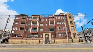 A multi-story hotel with a brick facade, multiple balconies, and a central entrance. - Perfect location! Right downtown! Walking distance to everything. (Grand Haven)