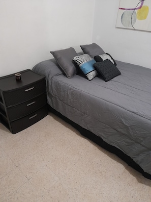 Cozy bedroom with a single bed, nightstand, and artwork.