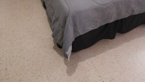 Une chambre à coucher avec un lit, une table de chevet et une œuvre d’art murale.