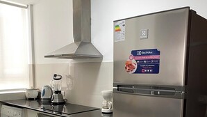 A modern kitchen with a stainless steel refrigerator, a built-in oven, a microwave, and a coffee maker. - Bright 2BR Apartment Steps from El Olivar Park (San Isidro)