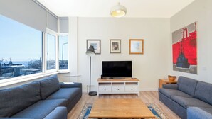 A modern living room with a large window, a flat-screen TV, and a sofa set. - Spacious 3BR Apartment · Bosphorus & Dolmabahçe View · Central Beyoğlu (İstanbul)
