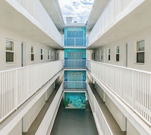 A multi-level corridor with balconies, windows, and a central atrium.